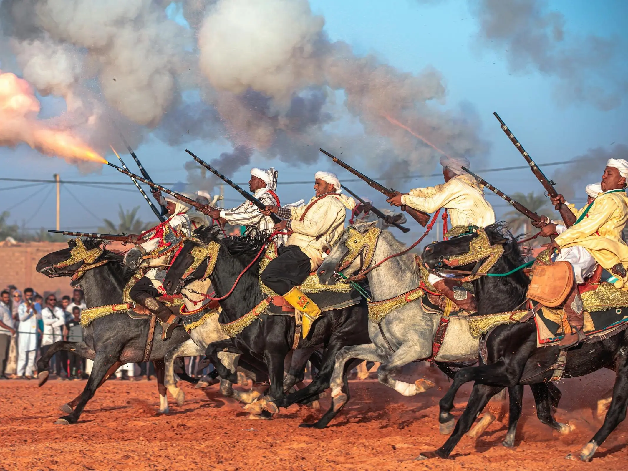 A line of men mounted on Barb horses running with guns