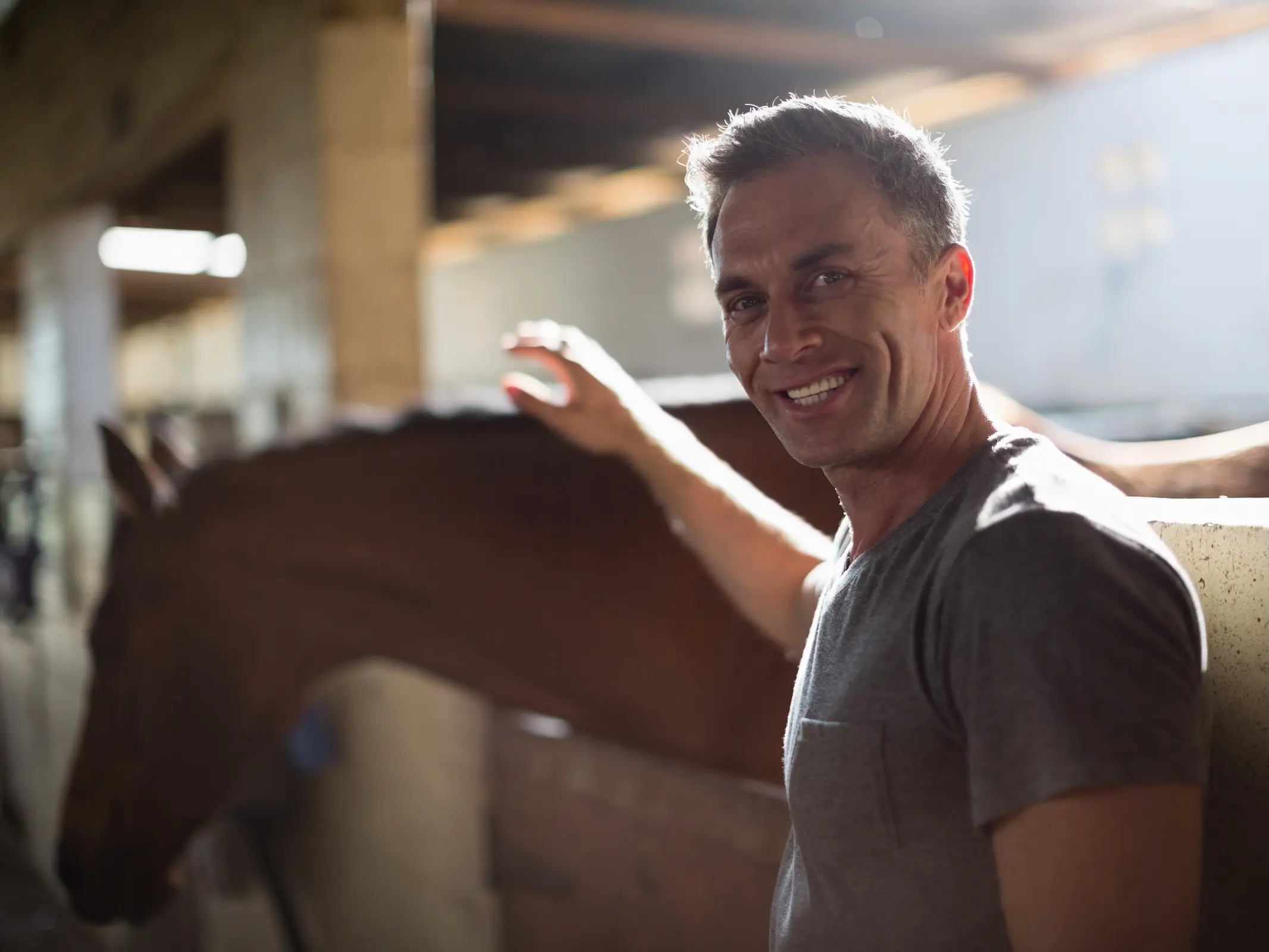 Smiling man petting a horse