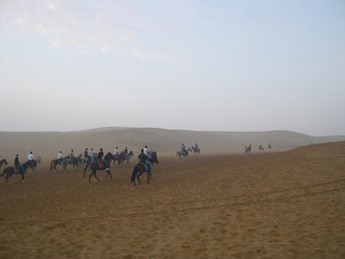 Men riding horses in the desert