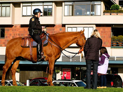Woman and child talking to mounted cop