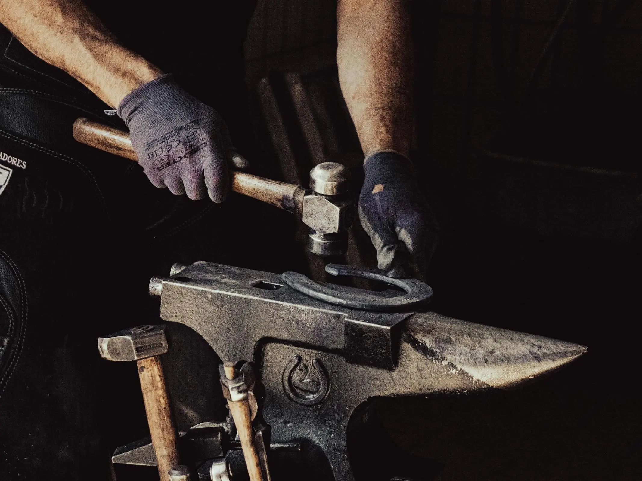 Man hammering a horse shoe