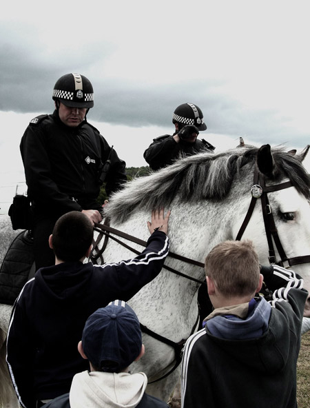 Mounted policemen stop to let kids pet their mounts