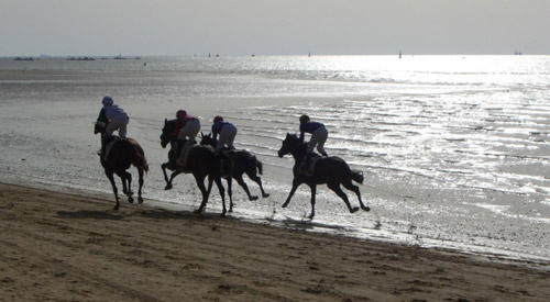 The 9 O'Clock Race 4 Horses and riders racing on the beach